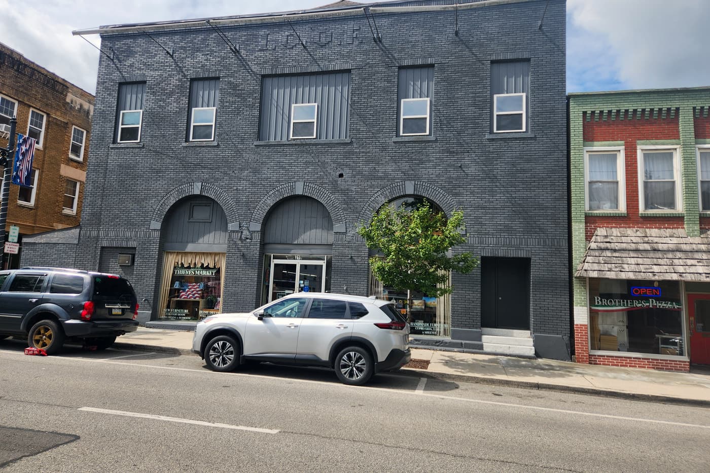 The grey brick front of Thieves Market at 219 N Front Street in Philipsburg, with three arched windows and the shop name in the glass